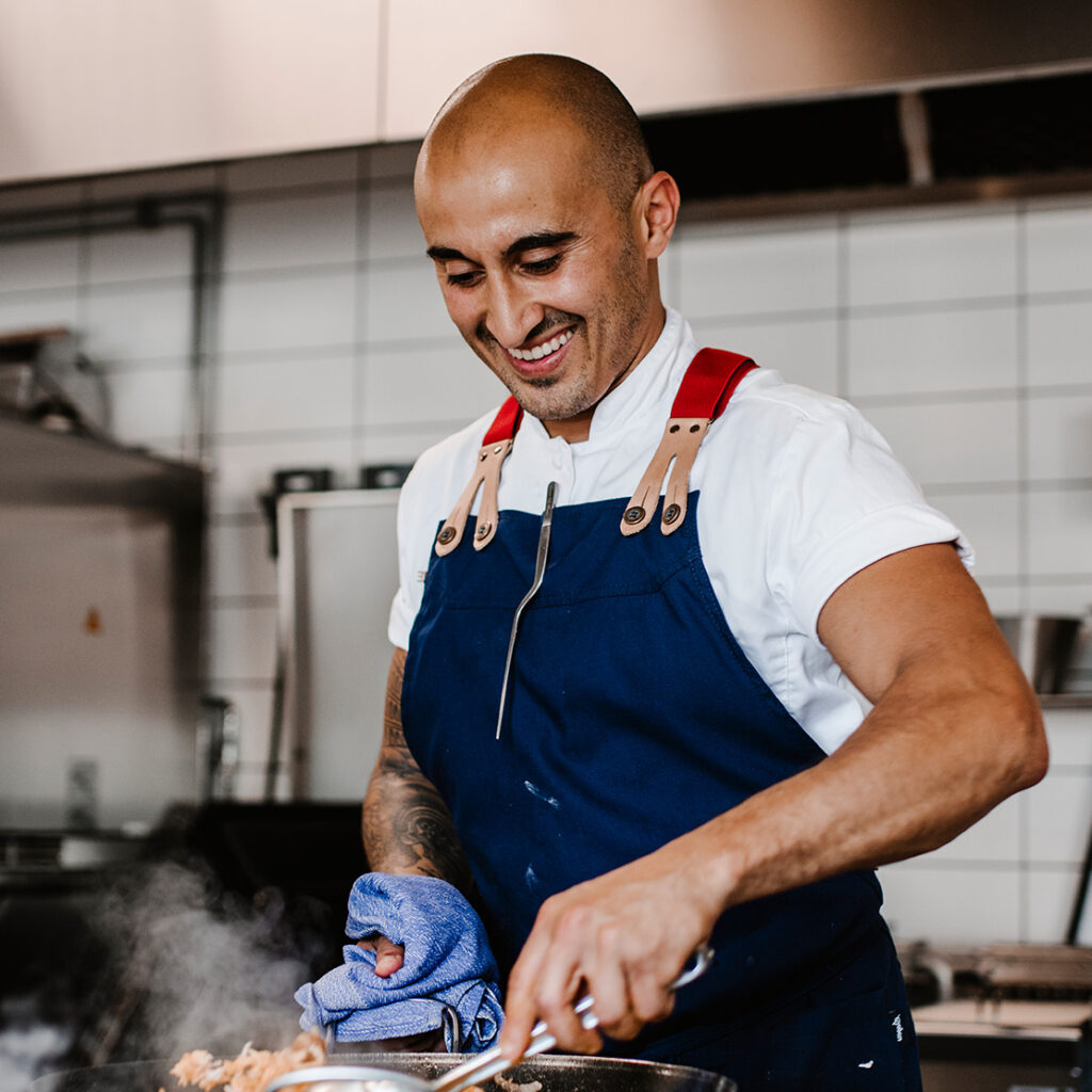 Koch oder Küchenmitarbeiter am Herd einer Restaurantküche